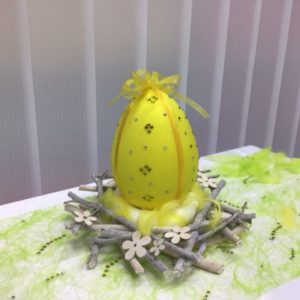 Osterei, Deko-Ei gelb im Weidekranz stehend